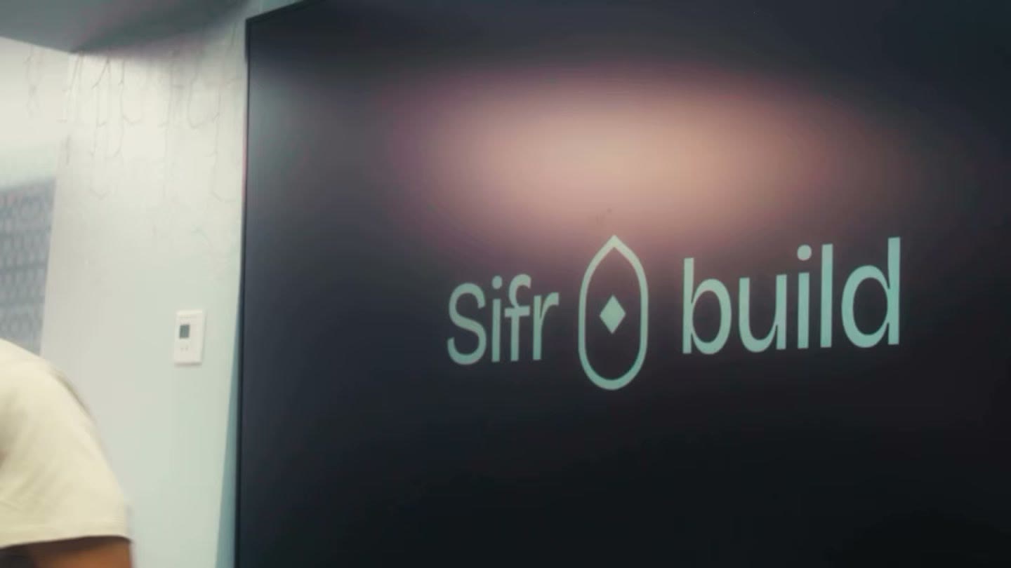A venue screen showing the Sifr and build lockup, with the mihrab mark between the two words.